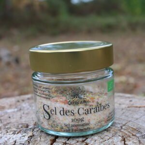 Pot en verre de Sel des Caraïbes Capsicam, sel coloré aux trois piments, posé sur une souche